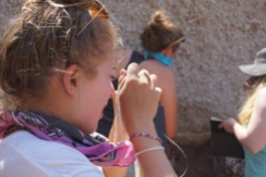 Emily using her hand lense to identify minerals in pumice